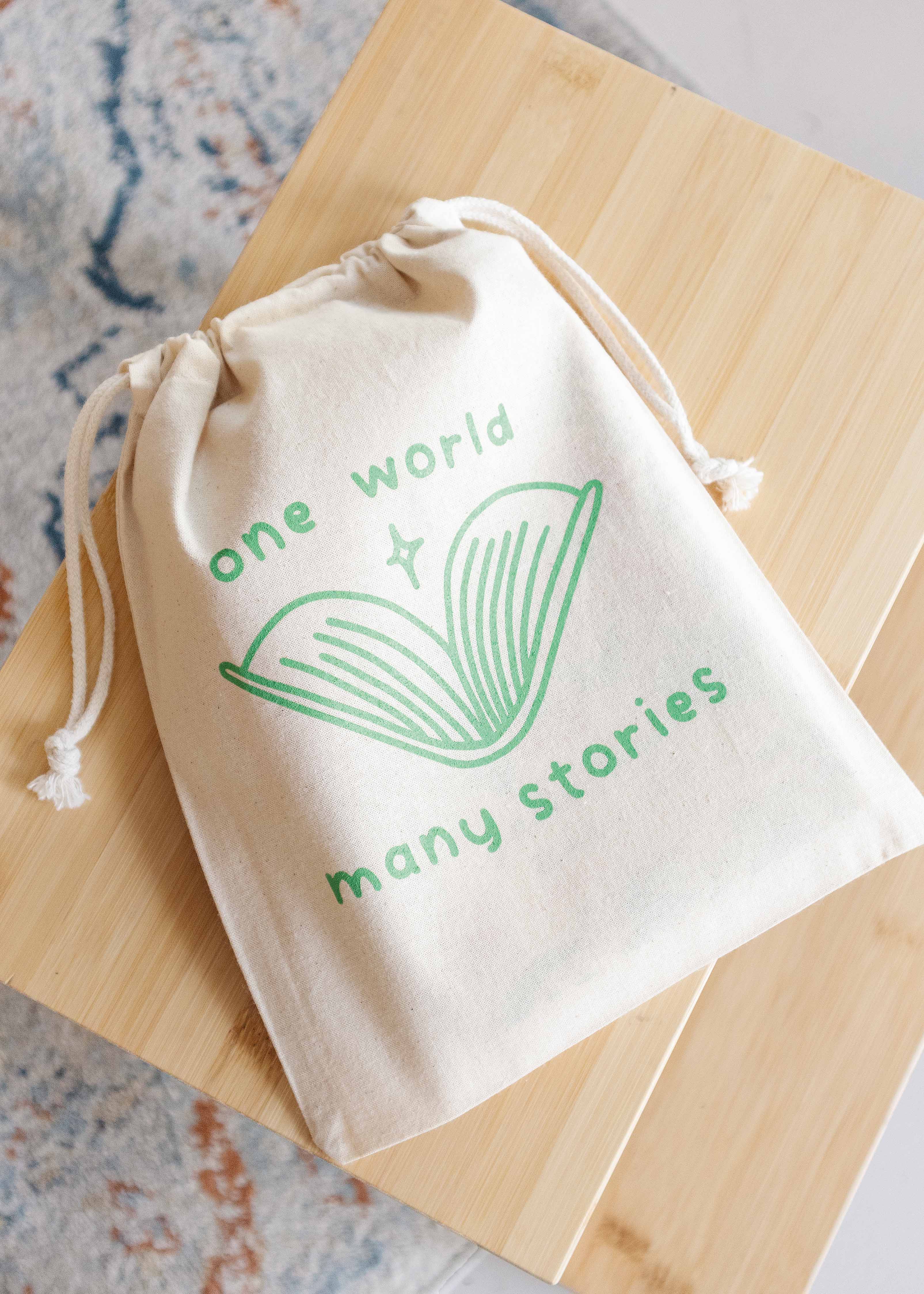 Booksleeve 'one world many stories green' klein