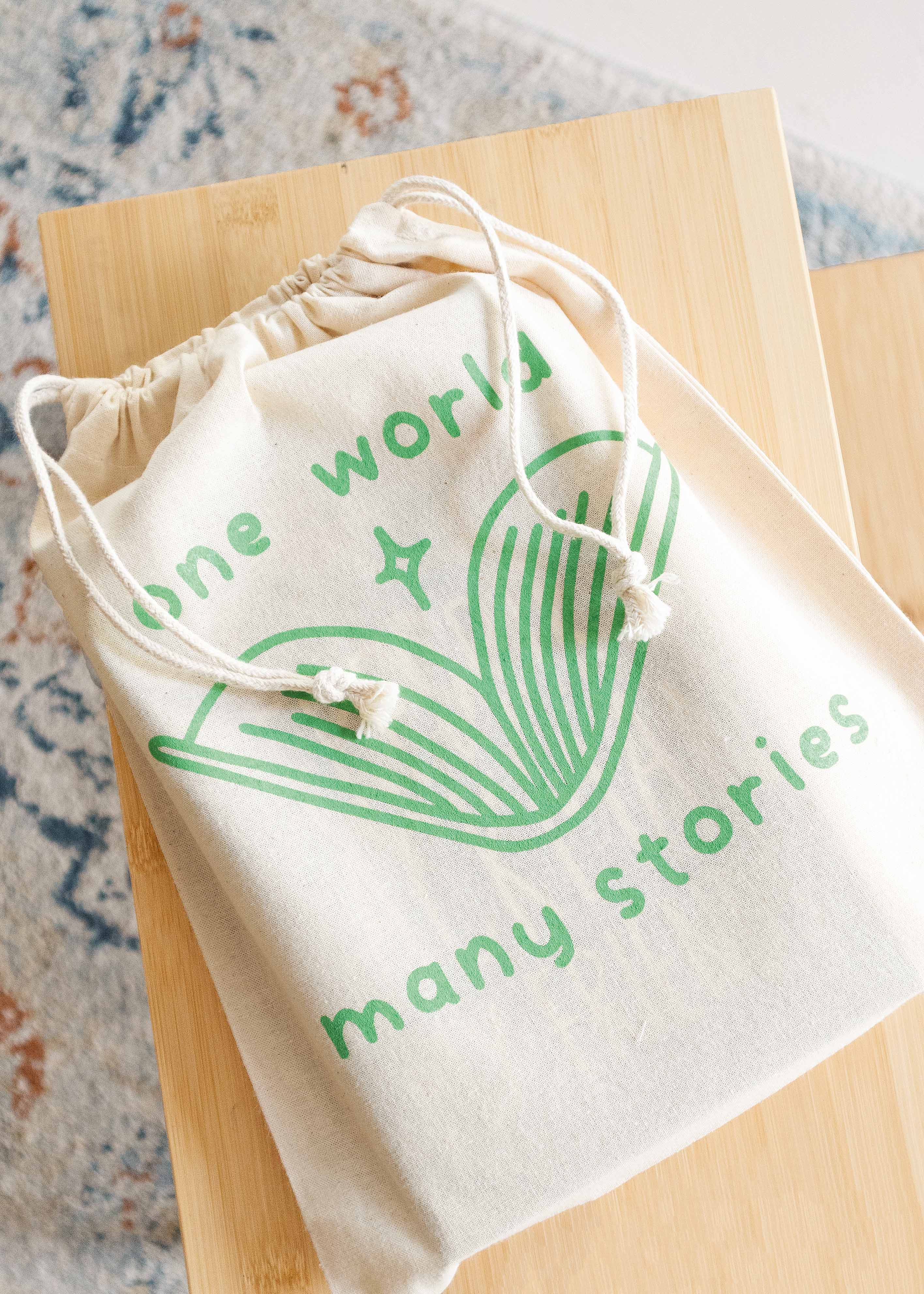 Booksleeve 'one world many stories green' groot