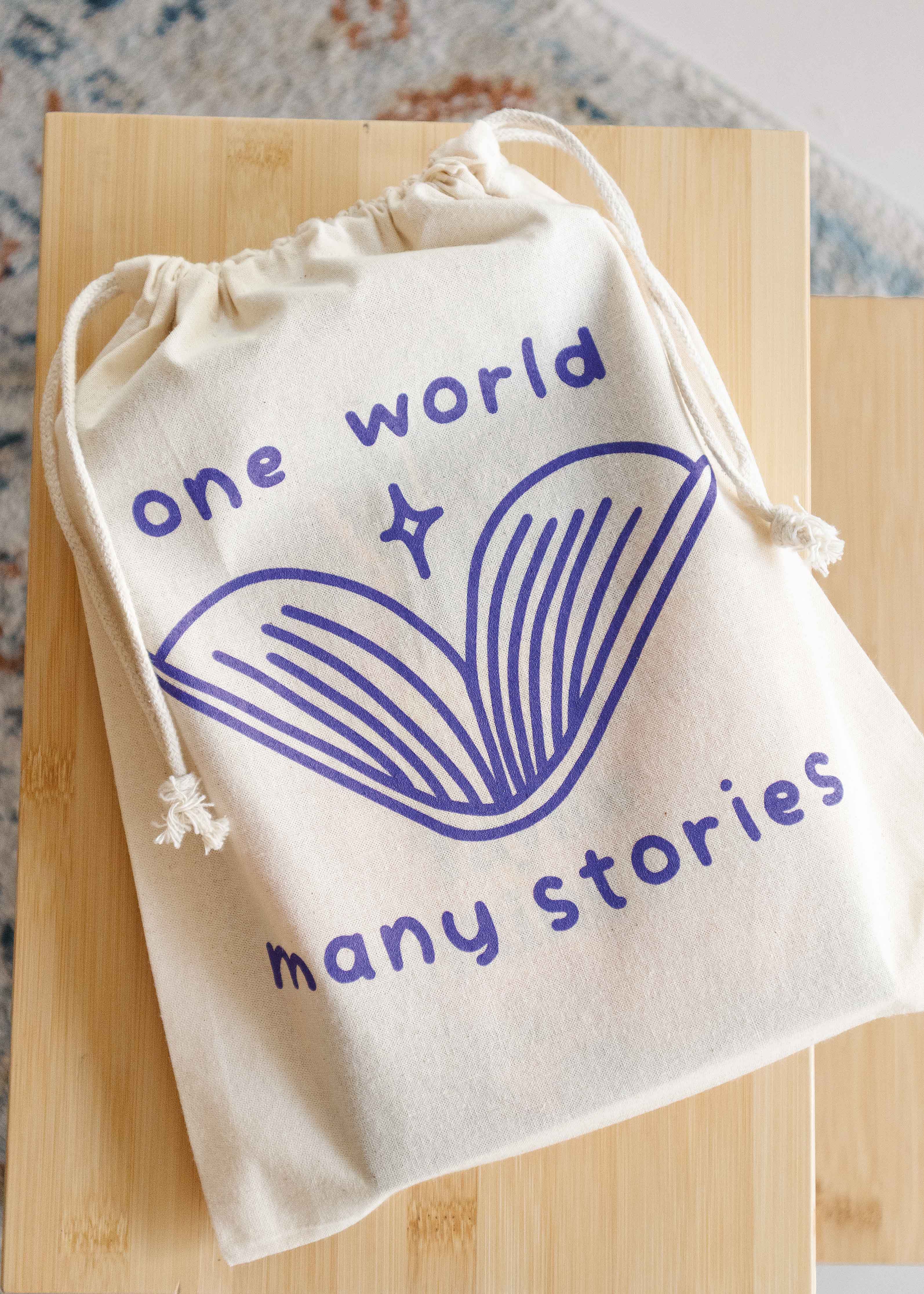 Booksleeve 'one world many stories purple' groot